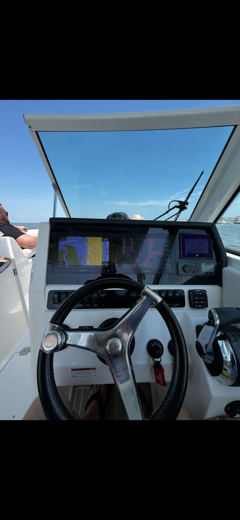 Slide: The Image of 2021 Sailfish 276 DC boat dashboard with steering wheel and navigation screens. - 5