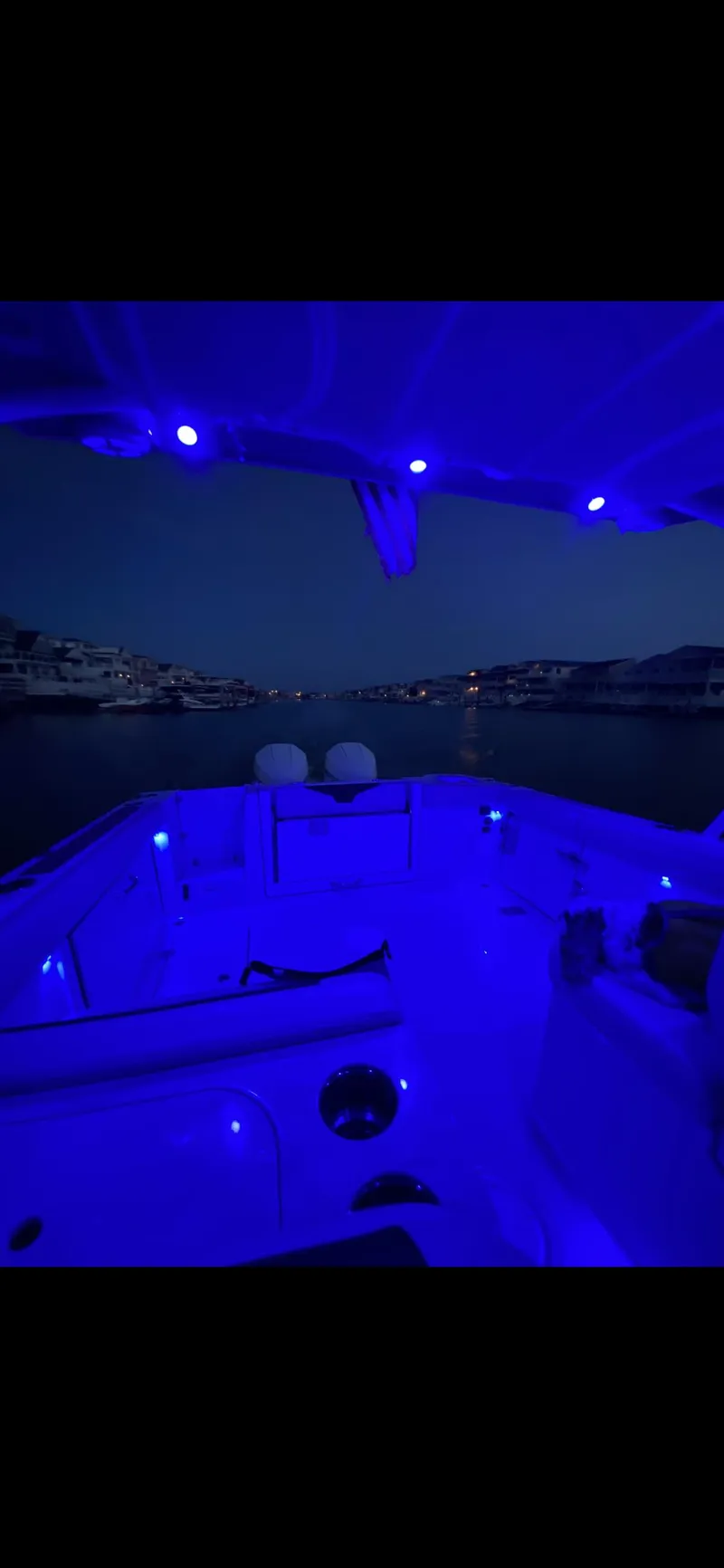 Slide: The Image of 2021 Sailfish 276 DC boat illuminated with blue LED lights at night. - 6