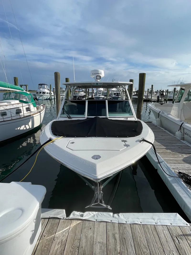 Slide: The Image of 2021 Sailfish 276 DC boat docked at marina under cloudy sky. - 8