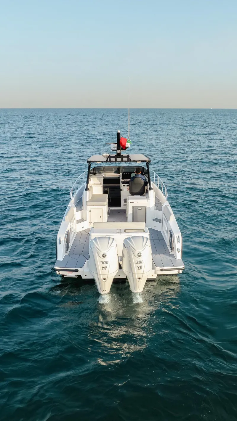Slide: The Image of Oryx 32 FX 2025 boat on open sea, rear view, twin engines visible. - 9