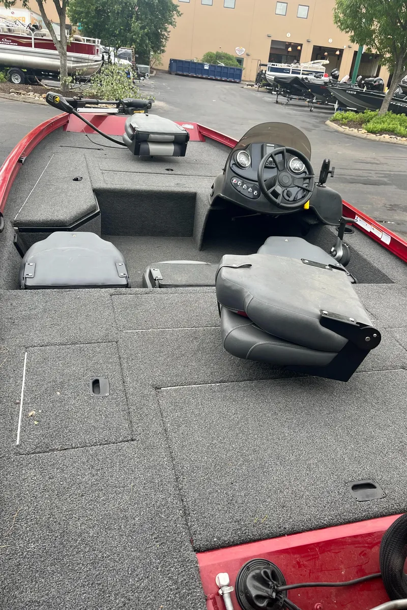 Slide: The Image of 2017 Lowe Stinger 175 boat interior with seating and control panel, parked outdoors. - 1