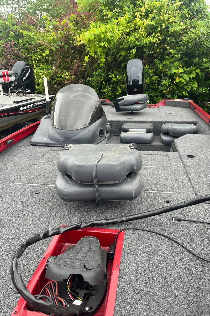 Slide: The Image of 2017 Lowe Stinger 175 boat interior with seating and control panel, surrounded by greenery. - 3