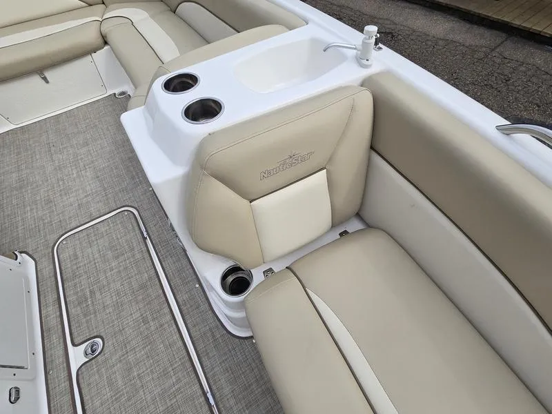 Slide: The Image of 2021 NauticStar 193 SC boat interior with beige seating and built-in cup holders. - 15