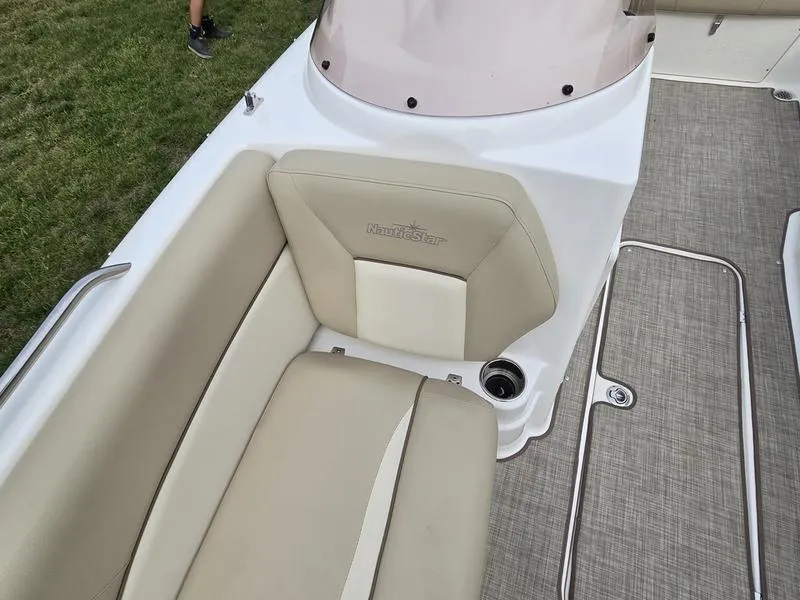 Slide: The Image of 2021 NauticStar 193 SC boat interior with beige seating and carpeted flooring. - 16