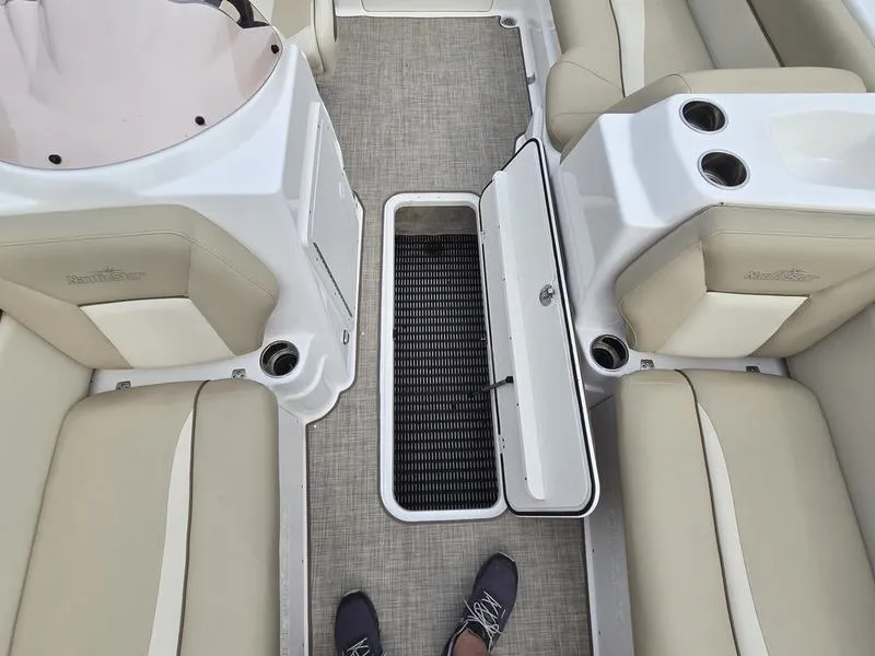 Slide: The Image of 2021 NauticStar 193 SC boat interior with open storage compartment and beige seating. - 17