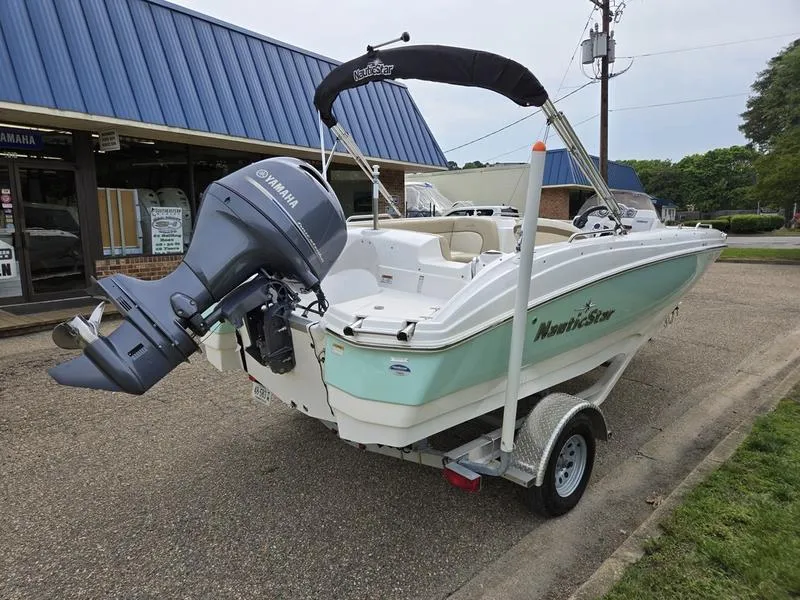 Slide: The Image of 2021 NauticStar 193 SC boat with Yamaha motor on trailer, parked outside a building. - 5