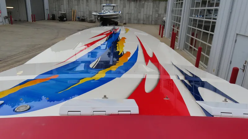 Slide: The Image of 2004 Cigarette 42 Tiger boat with vibrant, colorful graphics in a marina setting. - 25