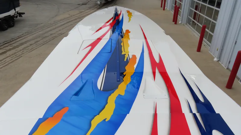 Slide: The Image of 2004 Cigarette 42 Tiger boat with vibrant red, blue, and yellow graphics on deck. - 27