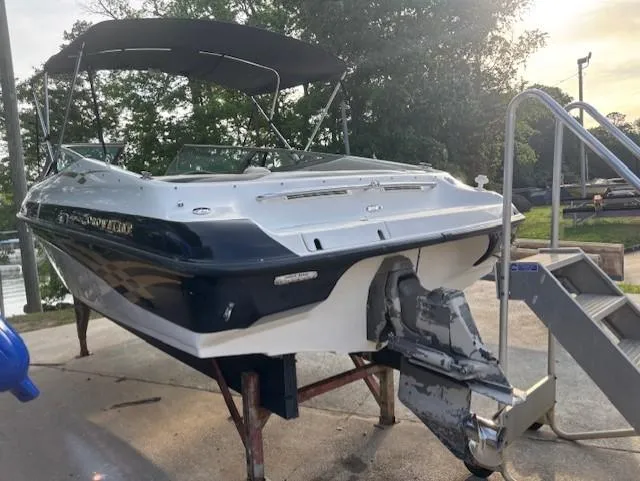 Slide: The Image of 1999 Crownline 202 boat on stand, with canopy, near water and trees. - 4