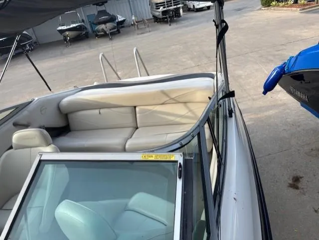 Slide: The Image of 1999 Crownline 202 boat interior with white seating, docked in a marina. - 6