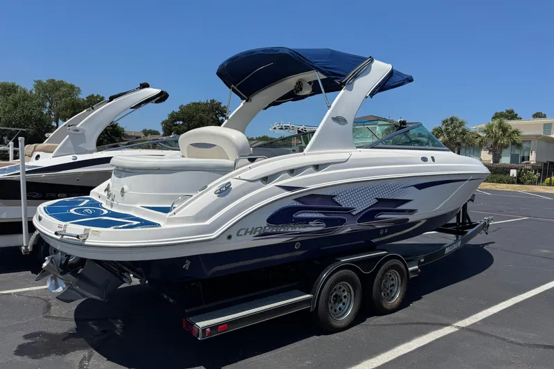 Slide: The Image of 2012 Chaparral 267 SSX boat on trailer, parked outdoors under clear blue sky. - 2