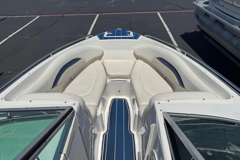 Slide: The Image of 2012 Chaparral 267 SSX boat interior with white and blue seating in a parking lot. - 3