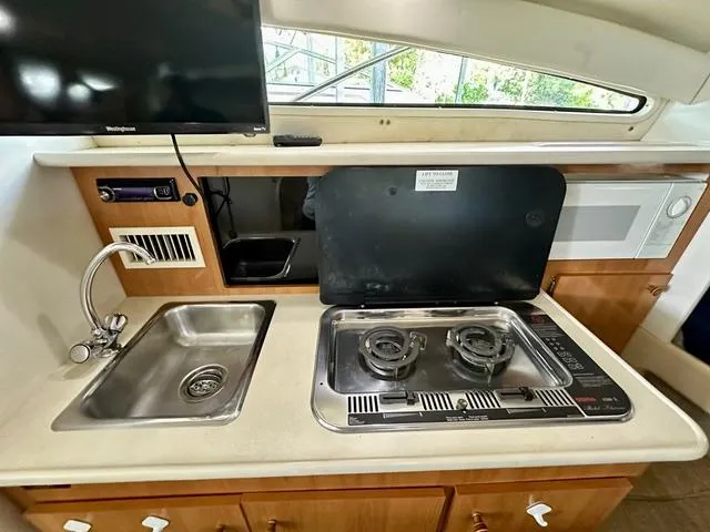 Slide: The Image of 2001 Bayliner 2855 Ciera kitchen with stove, sink, and microwave. - 16