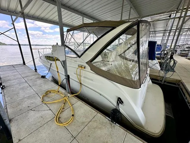 Slide: The Image of 2001 Bayliner 2855 Ciera docked under a covered marina with clear skies. - 2