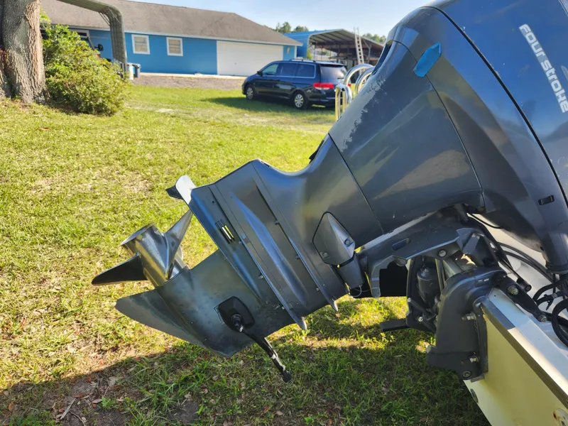 Slide: The Image of Outboard motor of a 2005 Key Largo 210 CC boat on grass. - 14