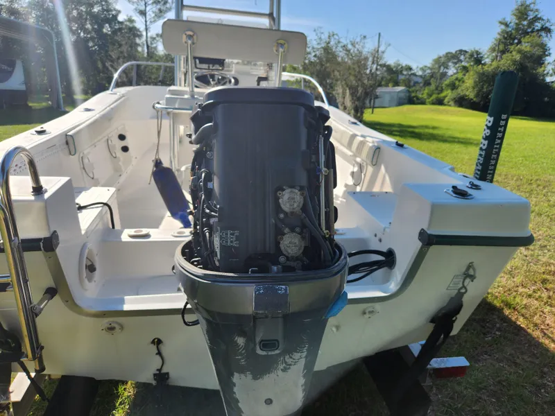 Slide: The Image of 2005 Key Largo 210 CC boat with outboard motor, parked on grass. - 19