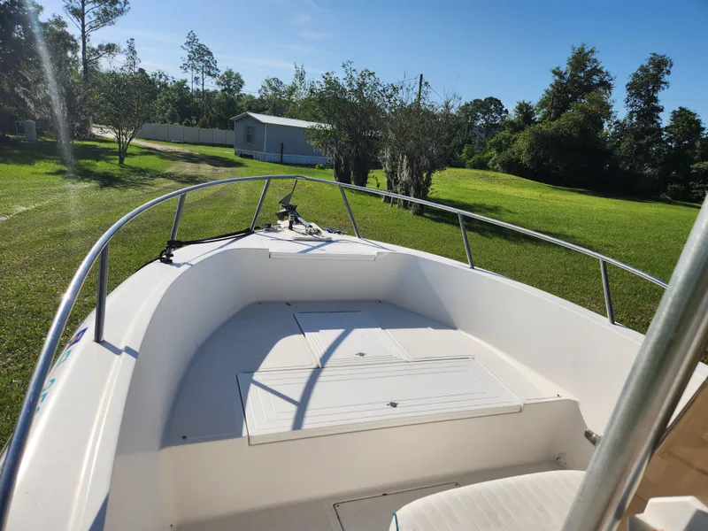 Slide: The Image of 2005 Key Largo 210 CC boat on grassy lawn with trees and blue sky. - 38