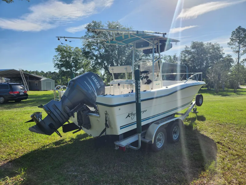 Slide: The Image of 2005 Key Largo 210 CC boat on trailer, parked on grass under clear sky. - 6