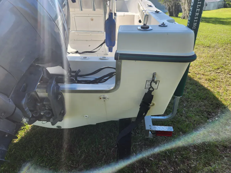 Slide: The Image of 2005 Key Largo 210 CC boat on trailer, showing engine and rear deck details. - 8