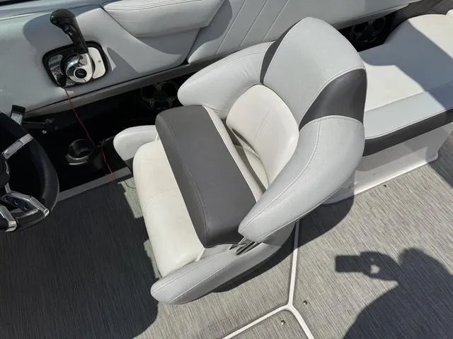 Slide: The Image of Captain's seat in a 2014 Regal 2300 boat, featuring gray and black upholstery. - 12