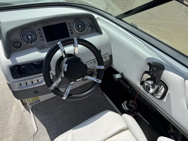 Slide: The Image of 2014 Regal 2300 boat dashboard with steering wheel and control panel. - 13