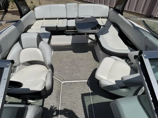 Slide: The Image of Interior of a 2014 Regal 2300 boat with white seating and a small table. - 8