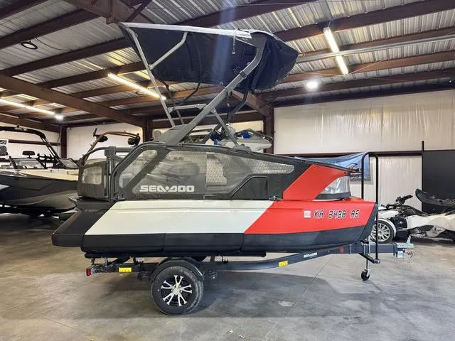 Slide: The Image of 2023 Sea-Doo Switch® Sport Compact-170 hp in storage, featuring a sleek red and white design. - 1