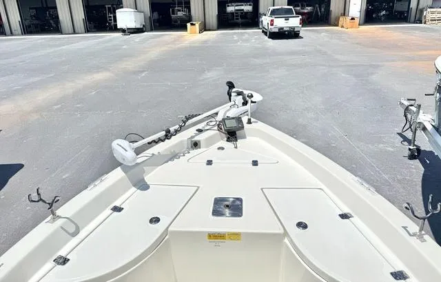 Slide: The Image of 2012 NAUTIC STAR 1810 CC boat bow view with trolling motor in a parking area. - 6
