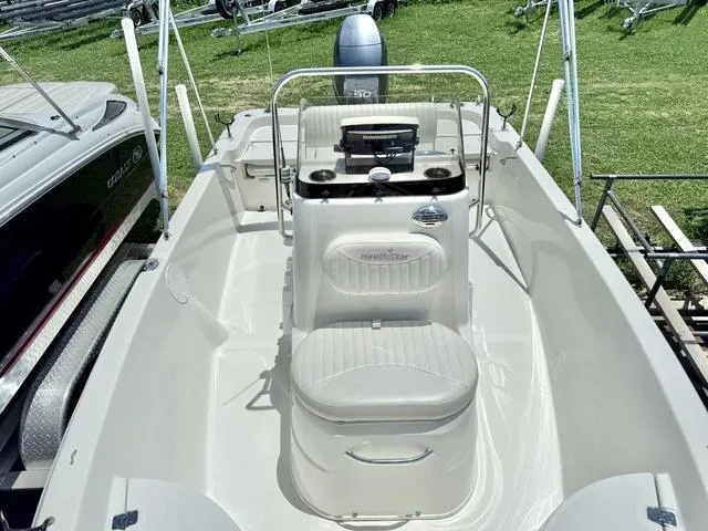 Slide: The Image of 2012 NAUTIC STAR 1810 CC boat interior with console and seating, displayed outdoors. - 9