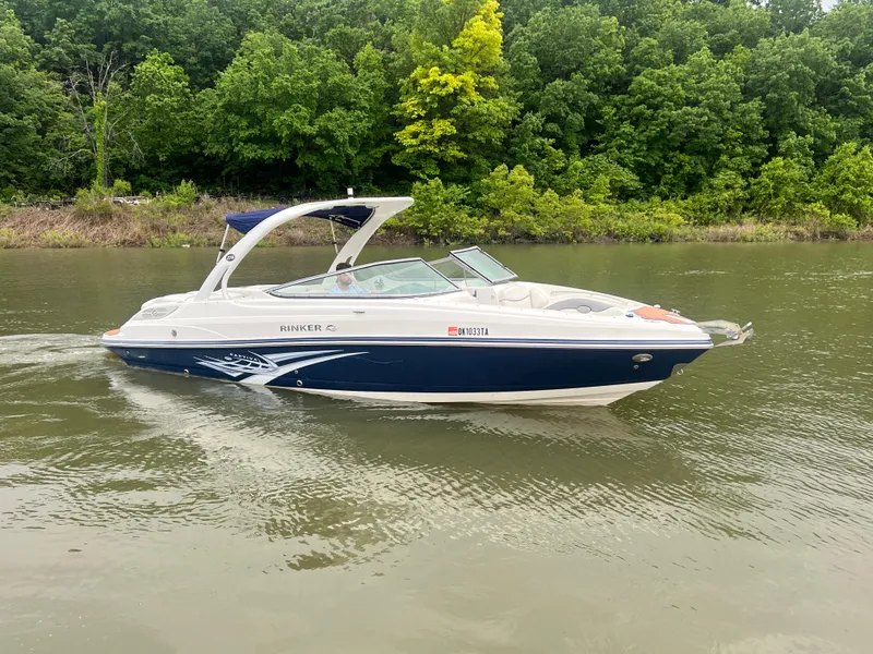 Slide: The Image of 2011 Rinker 276 Captiva Bowrider cruising on a calm river with lush green trees. - 10