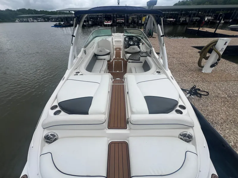 Slide: The Image of 2011 Rinker 276 Captiva Bowrider boat docked, featuring spacious seating and sleek design. - 17
