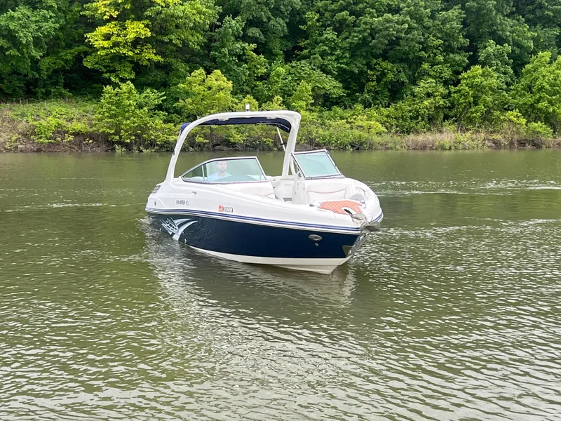 Slide: The Image of 2011 Rinker 276 Captiva Bowrider on a calm lake with lush green trees. - 2
