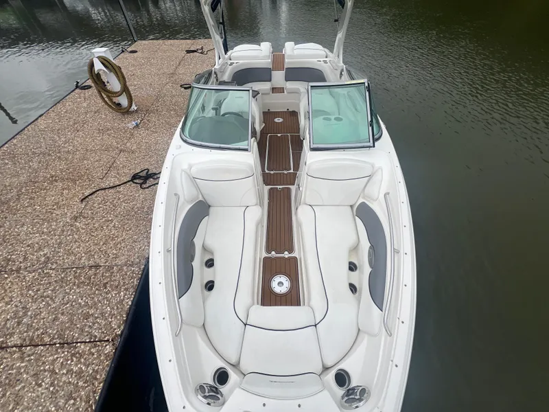 Slide: The Image of 2011 Rinker 276 Captiva Bowrider docked, featuring spacious seating and sleek design. - 25