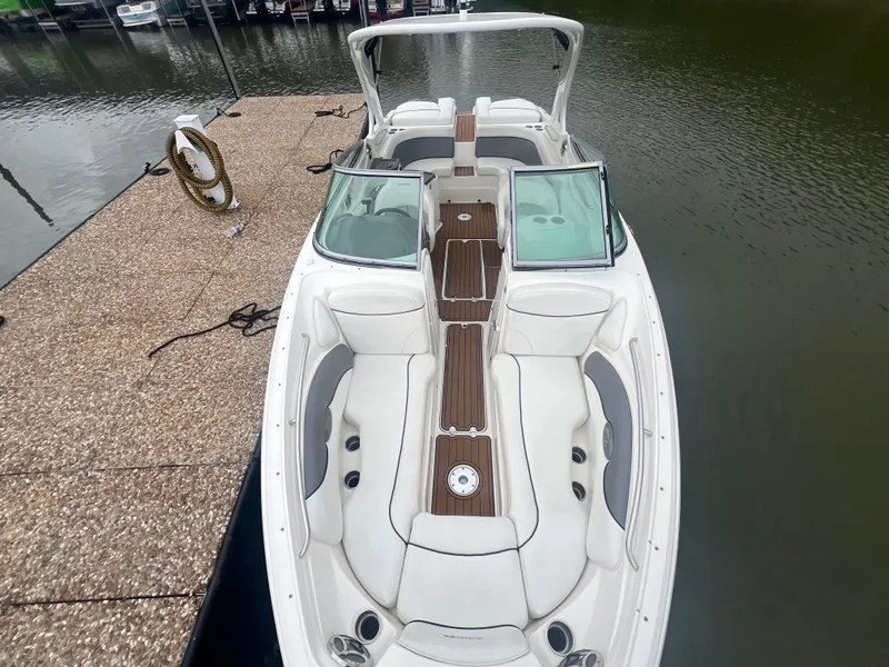 Slide: The Image of 2011 Rinker 276 Captiva Bowrider docked, featuring spacious seating and sleek design. - 26