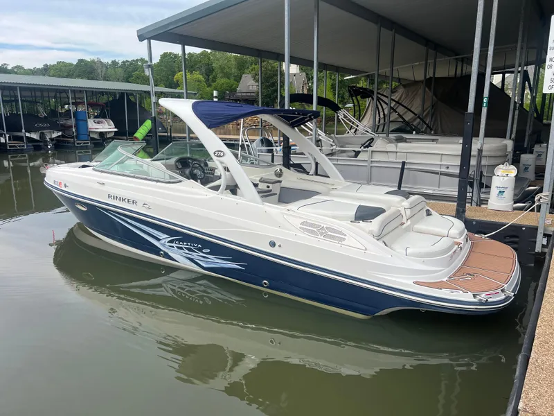 Slide: The Image of 2011 Rinker 276 Captiva Bowrider docked in a marina, featuring sleek design and spacious seating. - 3