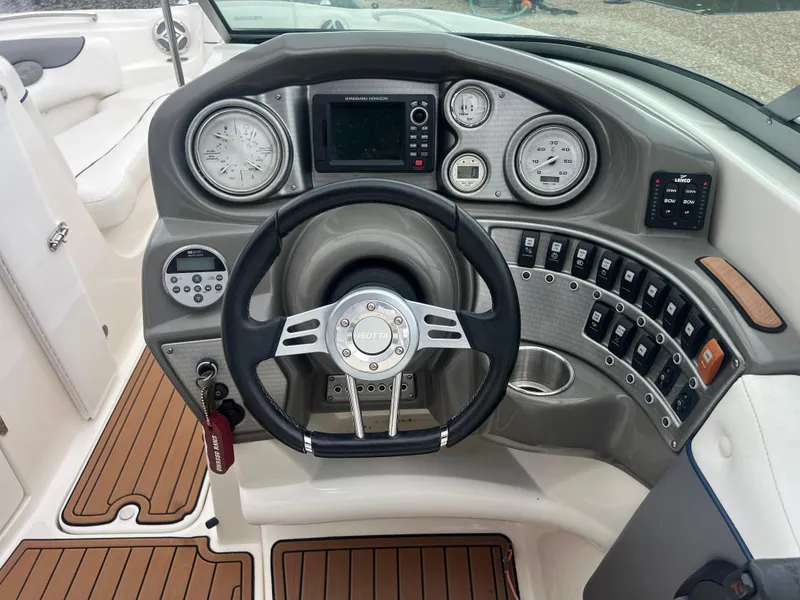 Slide: The Image of Steering console of 2011 Rinker 276 Captiva Bowrider with gauges and controls. - 32