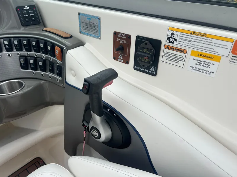 Slide: The Image of 2011 Rinker 276 Captiva Bowrider control panel with throttle and warning labels. - 33