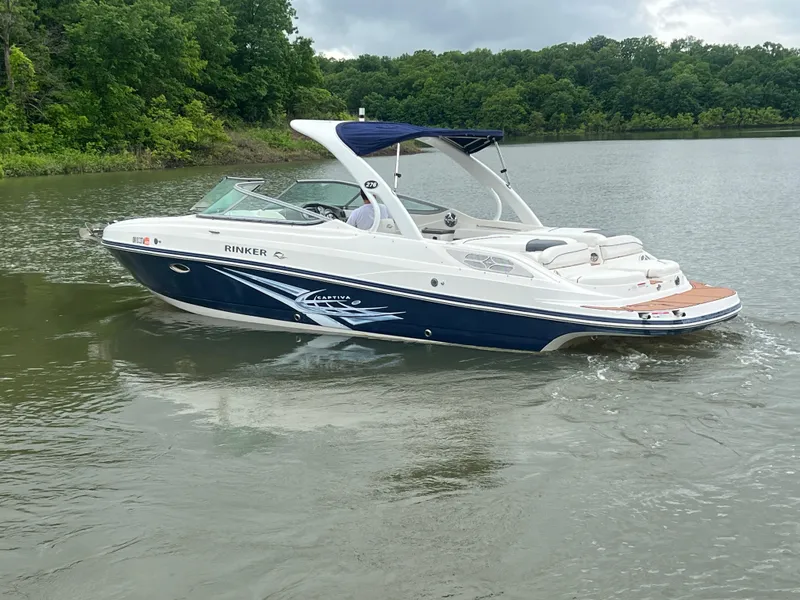 Slide: The Image of 2011 Rinker 276 Captiva Bowrider on a calm lake with lush green shoreline. - 4