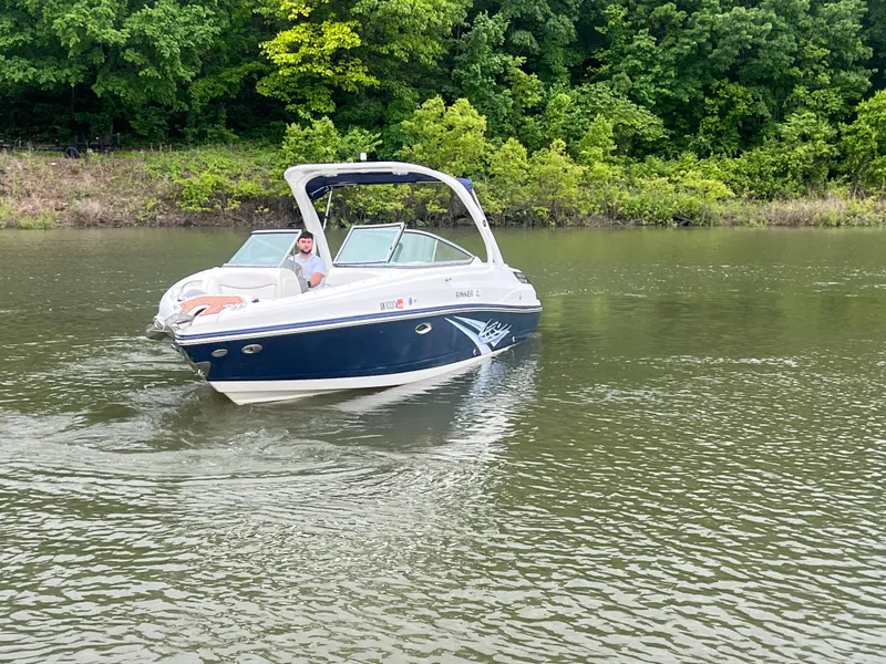 Slide: The Image of 2011 Rinker 276 Captiva Bowrider cruising on a calm river near lush greenery. - 5