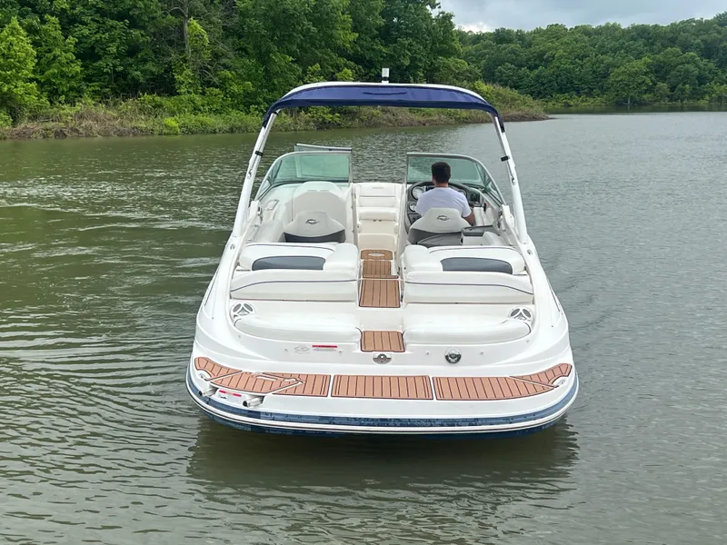 Slide: The Image of 2011 Rinker 276 Captiva Bowrider on calm lake, surrounded by lush greenery. - 7