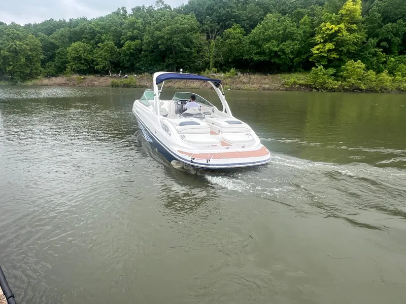 Slide: The Image of 2011 Rinker 276 Captiva Bowrider cruising on a calm lake with lush green trees. - 8