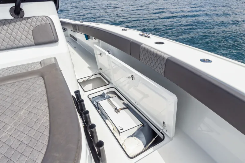 Slide: The Image of 2022 Freeman 34VH boat interior with open storage compartments, gray seating, and ocean backdrop. - 13