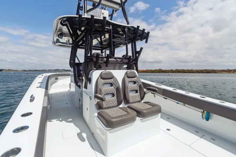 Slide: The Image of 2022 Freeman 34VH boat with dual seats, sleek design, and open deck on calm water. - 17