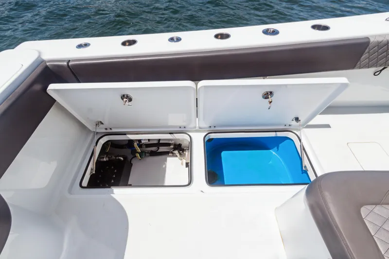 Slide: The Image of 2022 Freeman 34VH boat storage compartments open on deck by the water. - 18