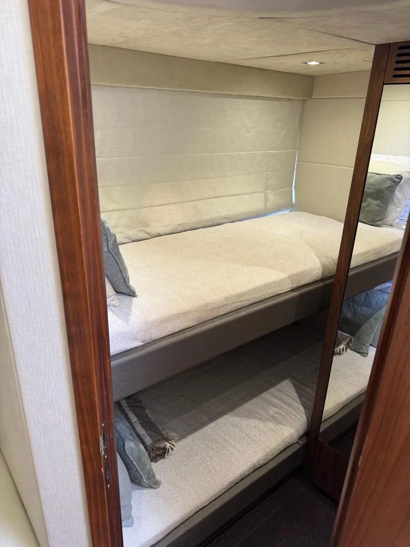 Slide: The Image of Bunk beds in 2017 Sunseeker Predator 57 yacht cabin, featuring cozy bedding and wooden accents. - 21