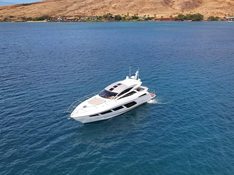 Slide: The Image of 2017 Sunseeker Predator 57 yacht cruising on blue ocean near a scenic coastline. - 4