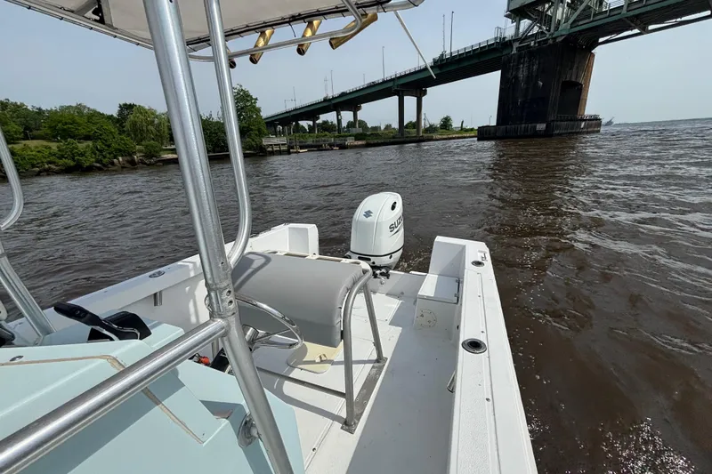 Slide: The Image of 1998 Sea Ox 20'6" boat on water near a bridge, featuring an outboard motor. - 10