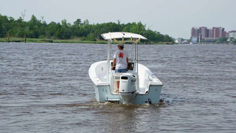 Slide: The Image of 1998 Sea Ox 20'6" boat cruising on a river with a person steering. - 4