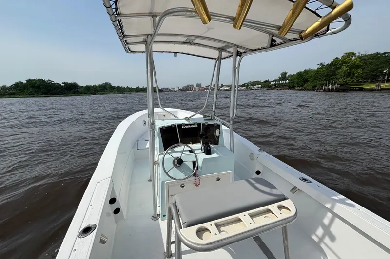 Slide: The Image of 1998 Sea Ox 20'6" boat on a river, featuring a center console and canopy. - 7