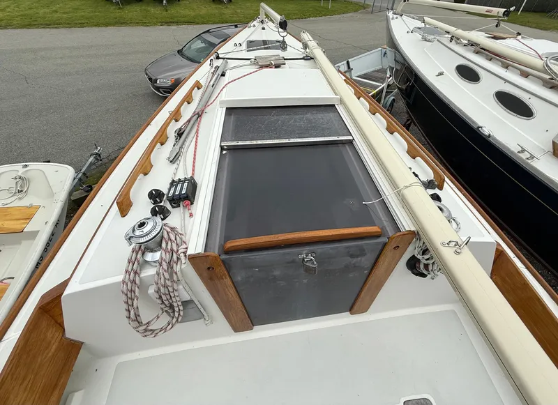 Slide: The Image of 1997 Alerion Express 28 sailboat deck with ropes and hatch, docked beside other boats. - 3